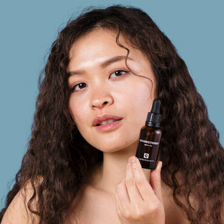 young woman with dewy skin and hydrextreme bottle