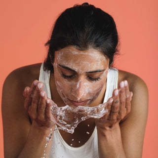 Woman washing away the natural foaming face wash